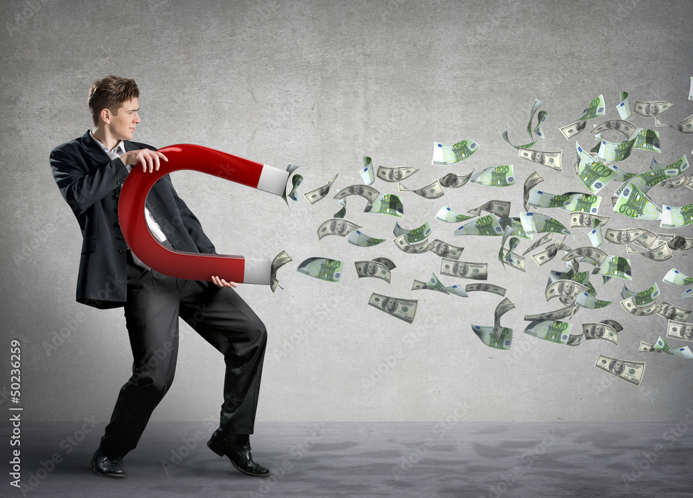 Businessman attracts money with a large magnet